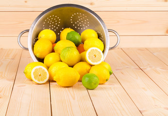 Composition of metal colander and lemons.