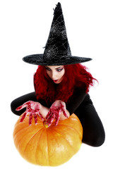 witch with bloodstained hands  sits on a pumpkin