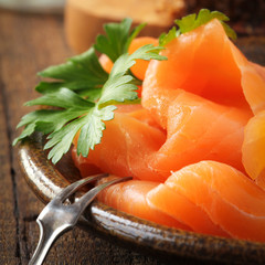 Slices of smoked salmon with a fresh leaf of parsley