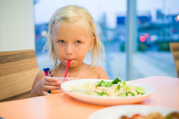 Obraz na płótnie Canvas Adorable girl dinning on food court with vegetables rice and jui