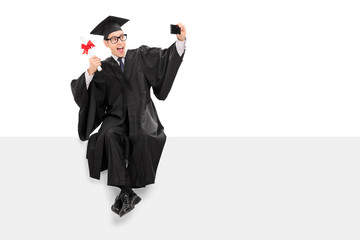 College graduate taking selfie seated on a panel