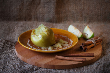 baked apple with cinnamon on plate, soft focus