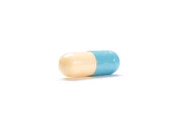 White and blue pill, isolated. Healthcare concept