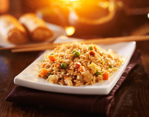 chinese vegetable fried rice on plate with orange glow