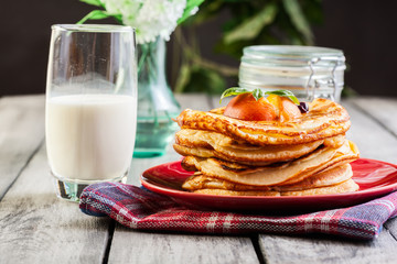 Pancakes with honey, fruit and glass of milk