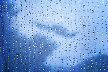 close up texture of water drop background on blue mirror use as