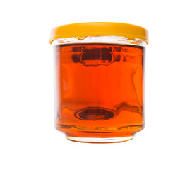 Honey in glass jar over white background