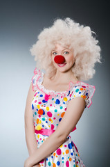 Clown with white wig against grey background