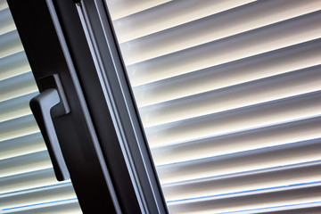 Jalousien als Sonnenschutz am Fenster
