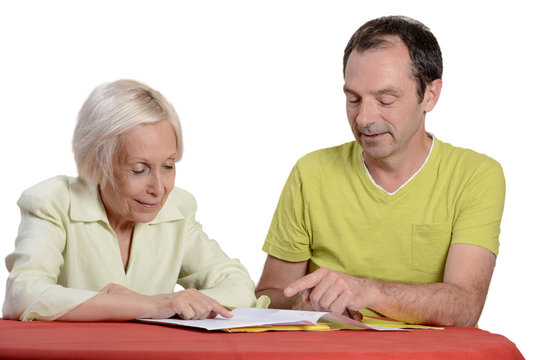 homme aidant une femme ag&eacute;e pour la d&eacute;claration d'imp&ocirc;t