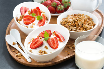 Fototapeta na wymiar healthy breakfast - yogurt, fresh strawberries, granola and milk