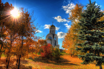 Church in the autumn forest on a background beautiful sky
