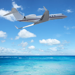 Fototapeta na wymiar Private jet plane over the tropical sea