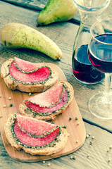Slices of italian salami with pears and wine