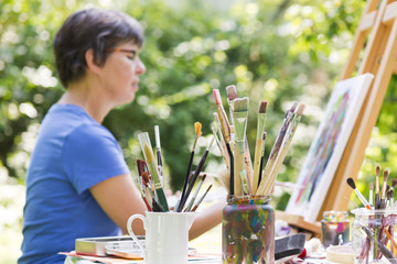 Frau malt ein Bild im Garten