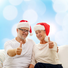 happy senior couple in santa helper hats