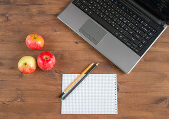apples, laptop, notebook and pencils