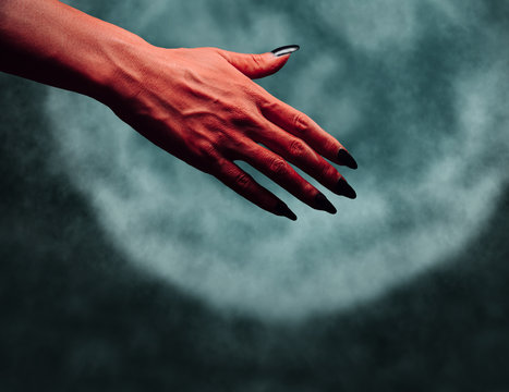 Devil hand with handshake gesture at midnight