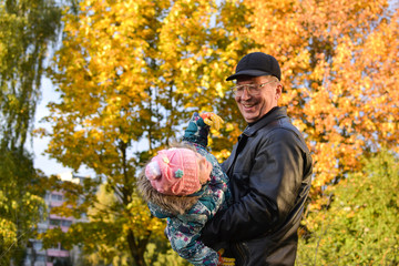 In autumn grandfather and granddaughter