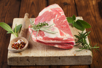 raw shoulder lamb on wooden board and table - 71509931