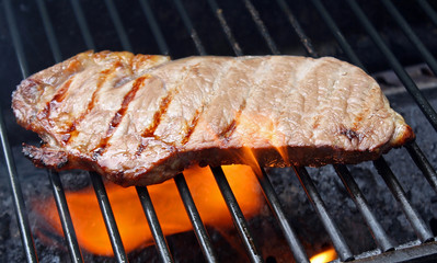 Steak Cooking Over Flames on The Grill