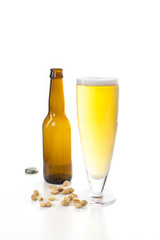 Full beer glass with an empty botlle in the bckground.