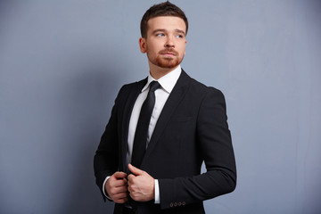 man adjusts his suit clothes