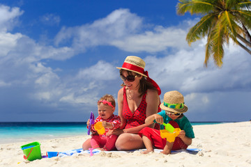 mother and kids playing on sand beach