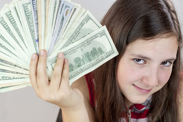Beautiful teen girl holding US dollars