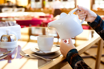 Woman's hands pouring tea