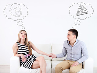 Obraz premium Dreaming concept. Loving couple sitting on sofa