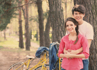Obraz premium Young couple with bicycles in park