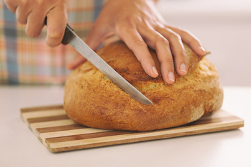 Woman's hands slicing bread