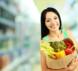 Shopping concept. Girl with package of food on shop background