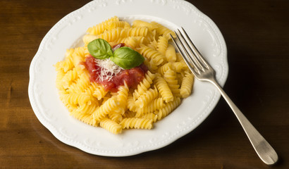dish with macaroni and tomato sauce on the wooden table