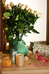 Obraz na płótnie Canvas Beautiful vase with roses near mirror
