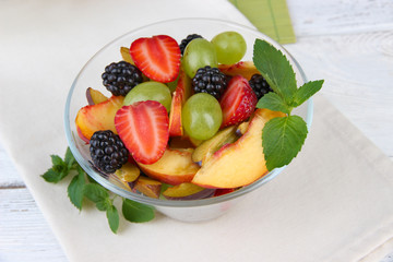 fresh tasty fruit salad on wooden table