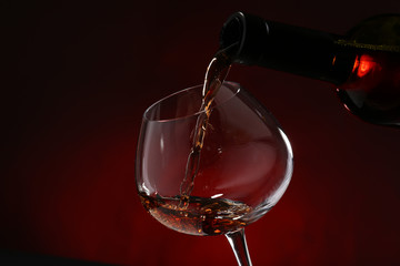 Red wine pouring into wine glass, close-up
