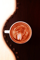 Cup of coffee with cute drawing in cafe