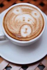 Cup of coffee with cute drawing in cafe