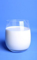 Milk in glass on blue background