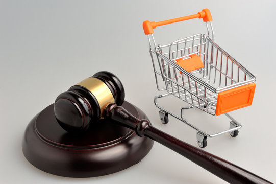 Hammer of judge and pushcart on gray