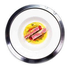 Grilled tuna steak with sauce, herbs in white plate