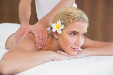 Obraz na płótnie Canvas Woman receiving shoulder massage at spa center