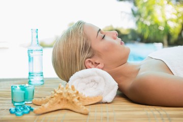 Fototapeta na wymiar Beautiful woman lying on massage table at spa center