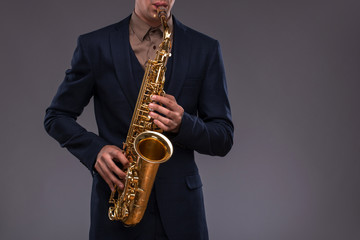 Naklejka premium Close-up picture of a trumpet in hands of a jazz man in a suit i