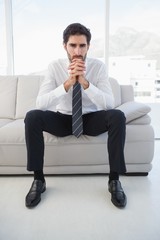 Serious businessman sitting on couch