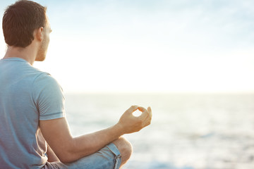young man in meditation near the sea