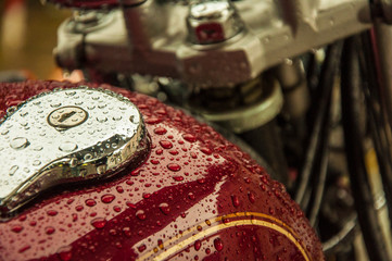 Drops of water on a red surface of a motorbike
