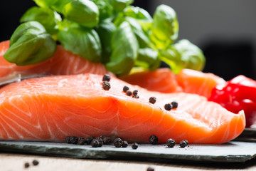 Fresh salmon fillet with basil and pepper close up